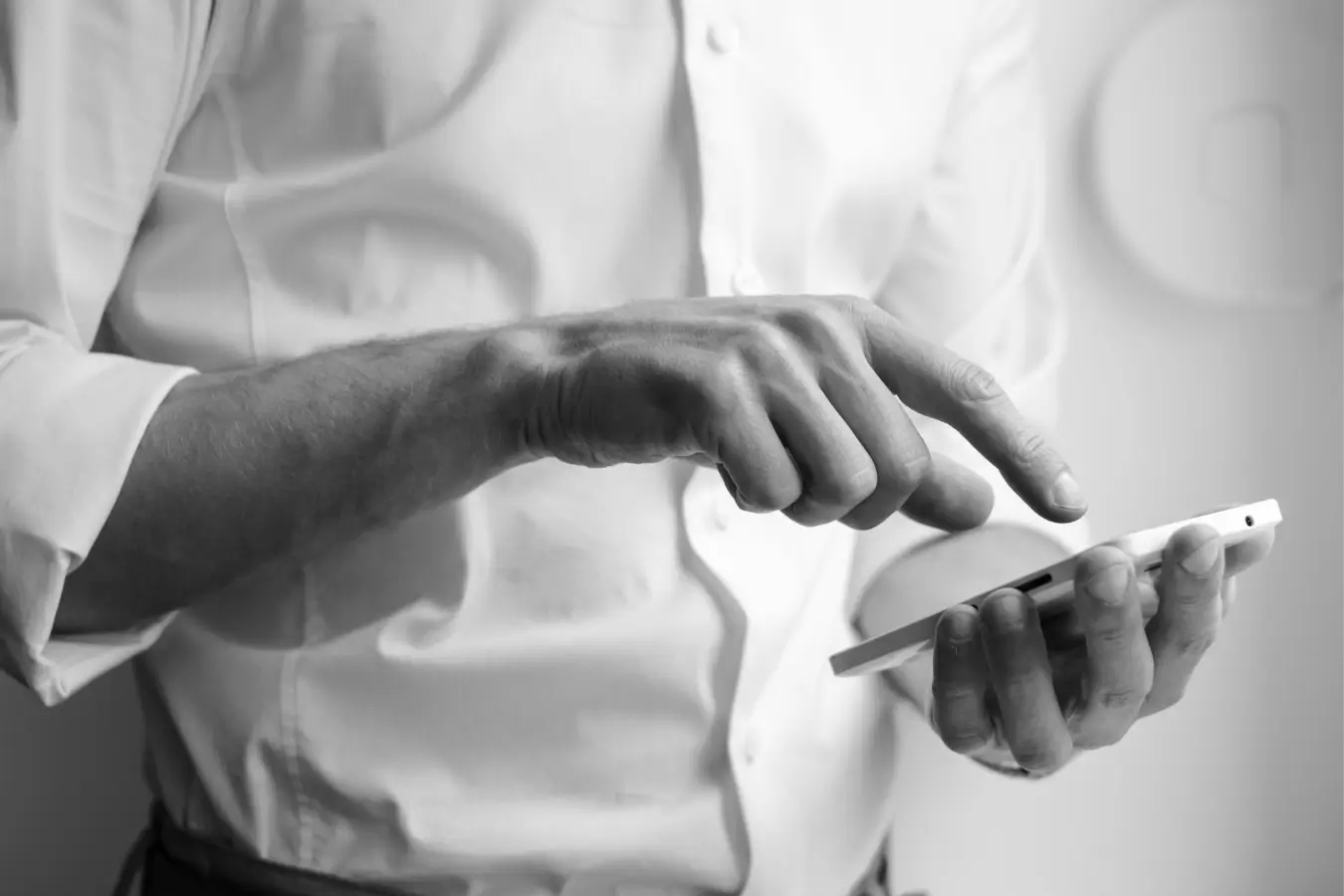 Close-up of a person using a smartphone, tapping the screen with one hand while holding the device with the other.