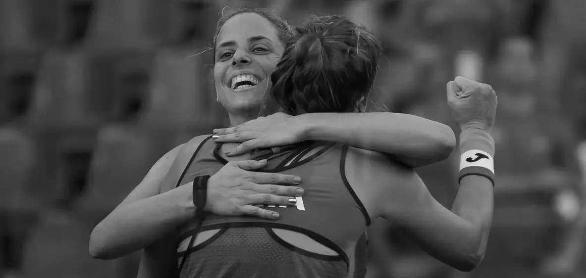 Two female padel teammates celebrating a victory, showcasing teamwork and camaraderie on the court.